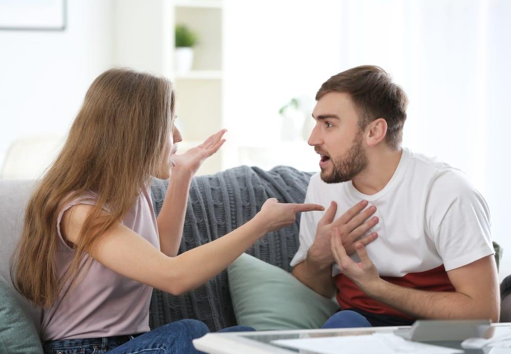 Couple arguing over credit card bills, highlighting money stress in modern relationships.