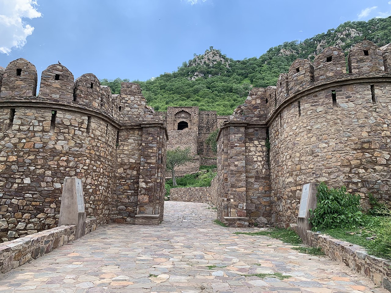 A wide view of the historic Bhangarh Fort ruins in Alwar, Rajasthan, surrounded by Aravalli hills.